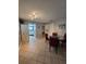Tiled dining room with a round glass table and decorative lighting fixture at 4401 Sea Mist Dr # 201, New Smyrna Beach, FL 32169