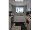 Cozy kitchen featuring white cabinets, stainless steel appliances, and a garden view window at 4401 Sea Mist Dr # 201, New Smyrna Beach, FL 32169