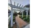 Brick walkway with a white pergola and manicured landscaping at 4401 Sea Mist Dr # 201, New Smyrna Beach, FL 32169