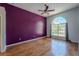 Bedroom featuring hardwood floors, a large arched window, and a ceiling fan at 4534 Bond Ln, Oviedo, FL 32765