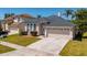 Inviting home showcases arched windows, manicured landscaping, a concrete driveway, and a two-car garage at 4534 Bond Ln, Oviedo, FL 32765