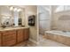 Bathroom featuring dual sinks, a vanity, tiled floors and walls, and a separate shower and tub at 481 W Holly Dr, Orange City, FL 32763