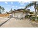 Charming home exterior with a spacious driveway and lush tropical landscaping at 481 W Holly Dr, Orange City, FL 32763
