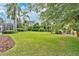 Expansive backyard with lush green grass and mature trees, creating a serene outdoor retreat at 483 N Pine Meadow Dr, Debary, FL 32713