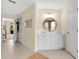 Bright bathroom featuring a white vanity, round mirror, and stylish floral wallpaper accent at 483 N Pine Meadow Dr, Debary, FL 32713