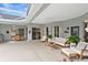 Open-air patio with plush seating, dining area, ceiling fans, and sliding doors for seamless indoor-outdoor living at 483 N Pine Meadow Dr, Debary, FL 32713