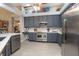Modern kitchen features stainless steel appliances, gray cabinets, quartz countertops, and wood-look flooring at 484 Lanarkshire Pl, Apopka, FL 32712