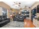 Open-concept living room boasts hardwood floors, modern furniture, and seamless flow into the kitchen at 484 Lanarkshire Pl, Apopka, FL 32712