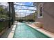 Indoor pool with crystal-clear water, a decorative fountain, and an enclosed screened lanai at 484 Lanarkshire Pl, Apopka, FL 32712