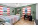 Bright bedroom with views, wood floors, TV, coastal decor, and red and white striped curtains at 5 Talo Cir, Port Orange, FL 32127