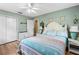Airy bedroom features wood floors, neutral tones, coastal decor, and a comfortable bed with pastel bedding at 5 Talo Cir, Port Orange, FL 32127