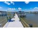 Wooden walkway leading to a waterfront boat dock with canopy, ideal for boaters seeking convenience and picturesque views at 5 Talo Cir, Port Orange, FL 32127