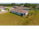 An aerial view of a single-Gathering home with a large backyard and an enclosed porch at 5064 Meadow Song Dr, Okahumpka, FL 34762