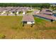 Aerial view of single-Gathering home with a large lawn surrounded by similar houses in a suburban neighborhood at 5064 Meadow Song Dr, Okahumpka, FL 34762