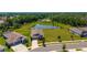 Aerial view of single Gathering home overlooking a pond surrounded by lush green landscaping at 5064 Meadow Song Dr, Okahumpka, FL 34762