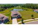 Aerial view of a single Gathering home overlooking a pond surrounded by lush trees at 5064 Meadow Song Dr, Okahumpka, FL 34762
