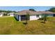 View of the home's backyard with a screened in porch and green lawn at 5064 Meadow Song Dr, Okahumpka, FL 34762