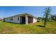 Lawn with enclosed patio featuring bright, lush grass, a young tree, and partial shade at 5064 Meadow Song Dr, Okahumpka, FL 34762