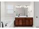 Bathroom view highlights a soaking tub, wood cabinetry, and double vanity at 5064 Meadow Song Dr, Okahumpka, FL 34762
