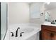 Bright bathroom with a soaking tub, marble surround, a dark faucet, and a privacy window at 5064 Meadow Song Dr, Okahumpka, FL 34762