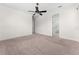 Large carpeted bedroom featuring a ceiling fan and ensuite bathrooms at 5064 Meadow Song Dr, Okahumpka, FL 34762