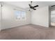 Spacious carpeted bedroom featuring a ceiling fan and large window at 5064 Meadow Song Dr, Okahumpka, FL 34762