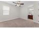 Carpeted bedroom with a ceiling fan and ensuite bathroom at 5064 Meadow Song Dr, Okahumpka, FL 34762