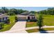 Exterior view of single-Gathering home with a two-car garage, water view and manicured lawn at 5064 Meadow Song Dr, Okahumpka, FL 34762