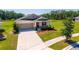 Charming single-Gathering home with a well-manicured lawn and two-car garage at 5064 Meadow Song Dr, Okahumpka, FL 34762