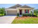 Inviting single-story home with a cozy front porch and manicured landscaping at 5064 Meadow Song Dr, Okahumpka, FL 34762