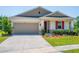Charming single-story home featuring a well-manicured lawn and a two car garage at 5064 Meadow Song Dr, Okahumpka, FL 34762