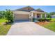 Well-maintained home featuring a two car garage and a charming front yard at 5064 Meadow Song Dr, Okahumpka, FL 34762