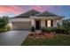 Charming single-story home with a two-car garage, landscaped yard, and covered entryway, perfect for curb appeal at 5064 Meadow Song Dr, Okahumpka, FL 34762