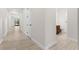 Hallway features modern tile floors leading towards the main living areas and bathrooms at 5064 Meadow Song Dr, Okahumpka, FL 34762