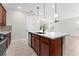 View of kitchen island with sink and faucet, with attached cabinetry and stainless dishwasher at 5064 Meadow Song Dr, Okahumpka, FL 34762