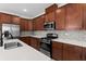 Spacious kitchen with stainless steel appliances, shaker cabinets, and stone countertops at 5064 Meadow Song Dr, Okahumpka, FL 34762