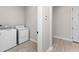 Laundry room with tile floors, white washer and dryer, and white walls at 5064 Meadow Song Dr, Okahumpka, FL 34762