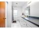 A white-themed bathroom with a vanity, toilet, mirror, and window providing natural light at 5410 Deleon Springs Ranch Rd, De Leon Springs, FL 32130