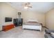 Spacious bedroom featuring a ceiling fan, a mounted TV, and a large safe at 5410 Deleon Springs Ranch Rd, De Leon Springs, FL 32130