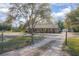 Charming single-story home with a gated entrance, a long driveway, and lush landscaping at 5410 Deleon Springs Ranch Rd, De Leon Springs, FL 32130