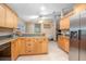 A kitchen with tiled floors, wooden cabinets, black appliances, and a window for natural light at 5410 Deleon Springs Ranch Rd, De Leon Springs, FL 32130