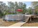 Inviting above-ground pool with decking, lounge space, and privacy in a lush, wooded backyard at 5410 Deleon Springs Ranch Rd, De Leon Springs, FL 32130