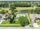 Aerial view of a home with a golf course, pond, and tree coverage nearby at 5479 Saint Regis Way, Port Orange, FL 32128