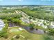 A picturesque aerial view showcasing a community with a golf course and a peaceful pond at 5479 Saint Regis Way, Port Orange, FL 32128