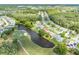 An aerial view of the community with a golf course and a scenic pond, surrounded by lush greenery at 5479 Saint Regis Way, Port Orange, FL 32128
