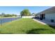 Backyard featuring a well-kept lawn, a patio, and a pond view at 5479 Saint Regis Way, Port Orange, FL 32128