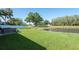 Landscaped backyard featuring a hot tub overlooking a pond surrounded by lush green grass and trees at 5479 Saint Regis Way, Port Orange, FL 32128