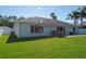 Spacious backyard featuring a well-kept lawn, a patio, and mature palm trees at 5479 Saint Regis Way, Port Orange, FL 32128