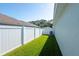 Landscaped backyard featuring a vinyl fence, a well-maintained lawn, and a home air conditioner at 5479 Saint Regis Way, Port Orange, FL 32128