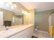 Well-lit bathroom featuring double sinks, a large mirror, and glass door shower at 5479 Saint Regis Way, Port Orange, FL 32128
